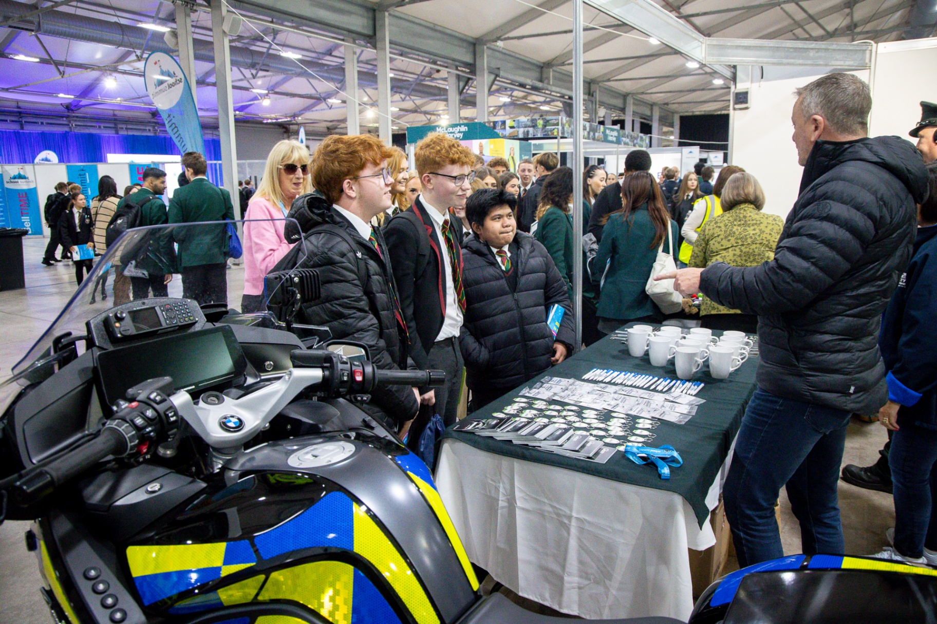 Pupils gathered next to a Northern Ireland Fire & Rescue Service fire engine with a firefighter at School Summit Northern Ireland, 2025.