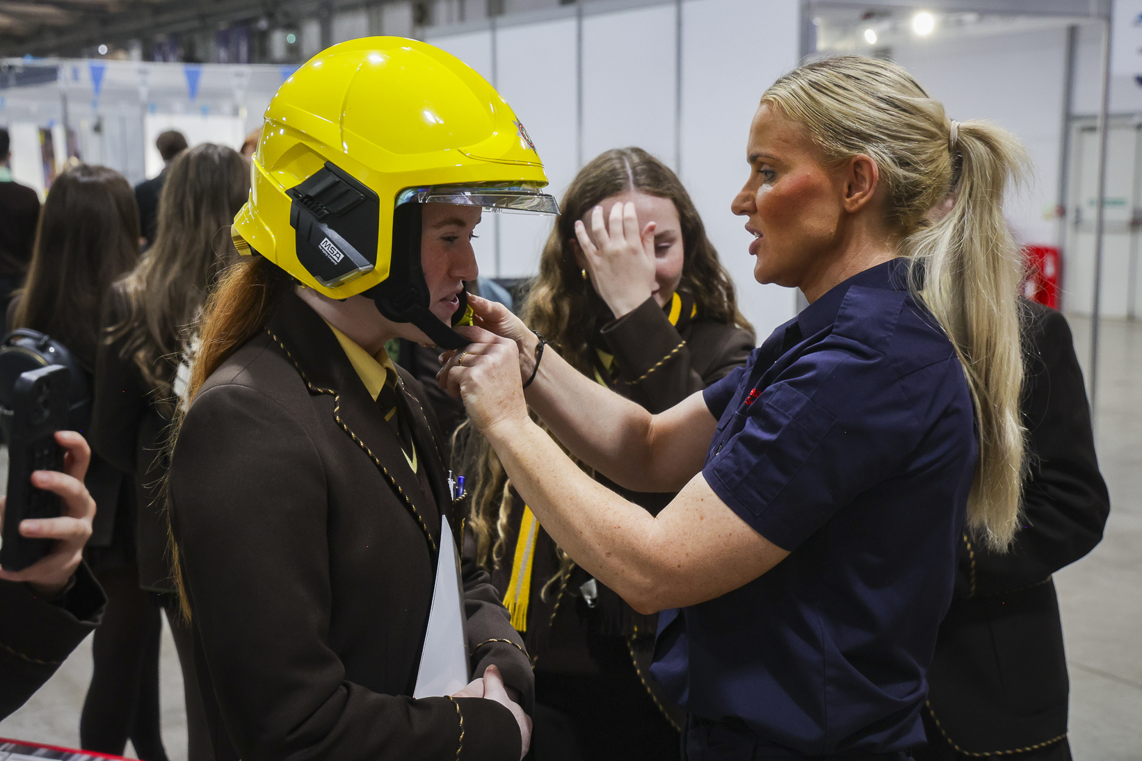Translink staff in high-visibility uniform speaking with pupils at their exhibitor stand at School Summit Northern Ireland, 2024.