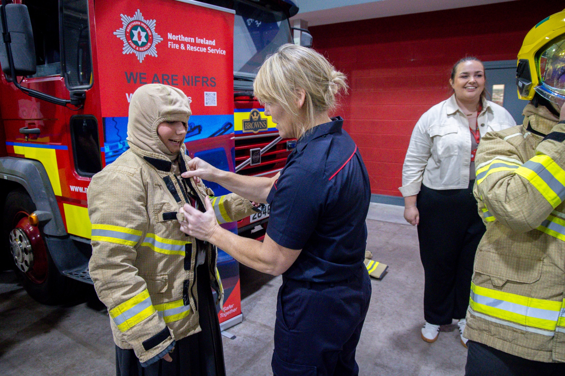 A Northern Ireland Fire & Rescue Service firefighter demonstrating equipment with a school pupil at School Summit Northern Ireland.