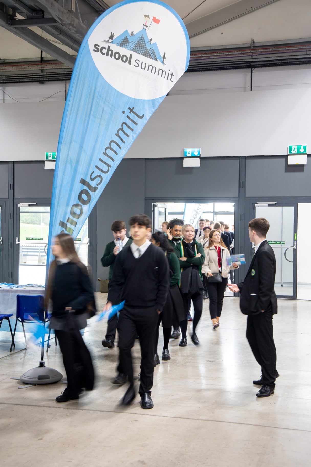 A FEED representative in conversation with pupils at their branded exhibitor stand at School Summit Northern Ireland, 2025.